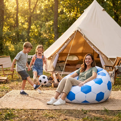 Maman sur son canapé gonflable en forme de ballon de foot regarde ses enfants jouer au ballon devant la tente.