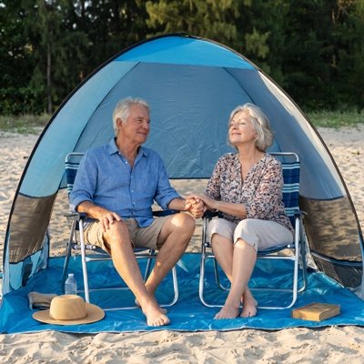 Couple age sous leur Tente de plage Bonheur devant conifères