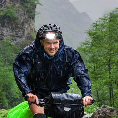 Cycliste sous la pluie, avec sa Lampe frontale rechargeable 