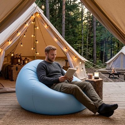 homme qui lit fauteuil gonflable devant tente