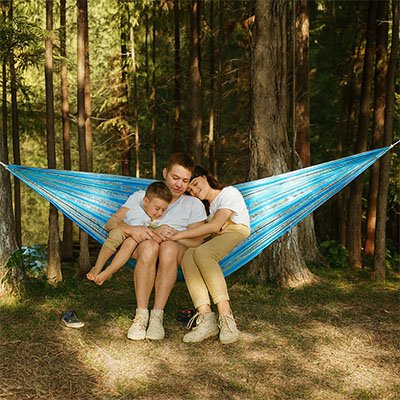 famille sur hamac suspendu léger et confortable dans forêt