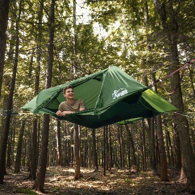 Un jeune homme dans son hamac tente refuge suspendu en forêt
