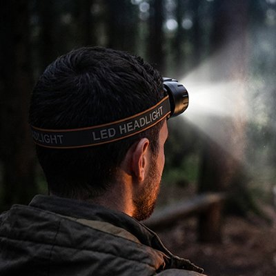Il se promène dans le bois avec sa lampe frontale confort puissant
