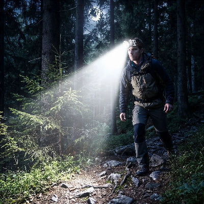 Homme en randonnée de nuit avec sa lampe frontale longue durée