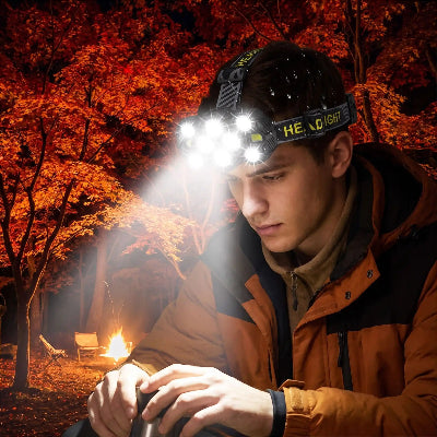 en automne dans l'érablière, il boit son café portant une lampe frontale puissante