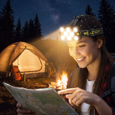 dans la nuit jeune femme étudie carte avec lampe frontale puissante