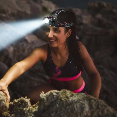 Jeune femme en escalade avec sa lampe frontale puissante
