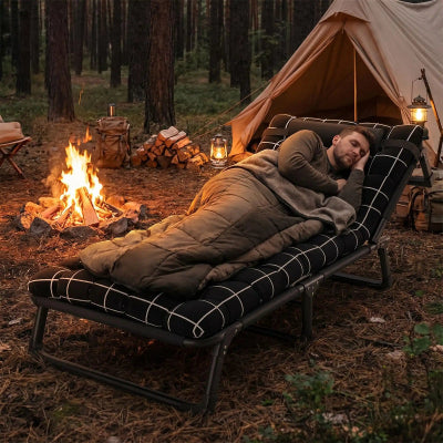 homme coucher sur lit de camping tente feu camp foret coucher soleil 