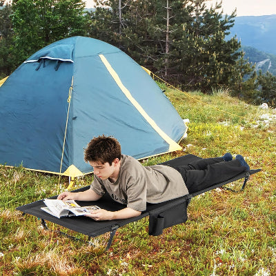 ado etudie sur son lit de camping pres tente bleue