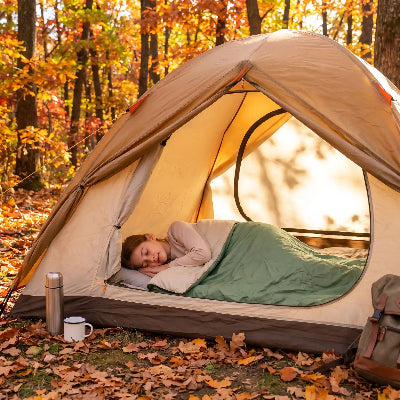en automne ell se reveille dans son sac de couchage impermeable dans erabliere