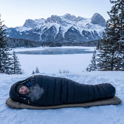 Homme dort dans sac de couchage grand pour froid premium près lac gelé