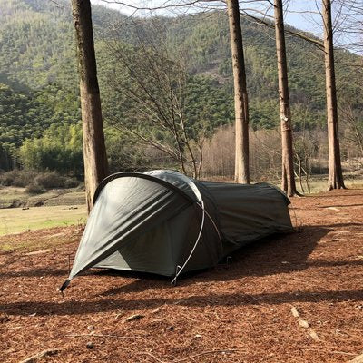 Tente trekking légère, près d'une rangée d'arbres.